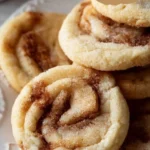 Soft and chewy cinnamon roll cookies with icing on a plate