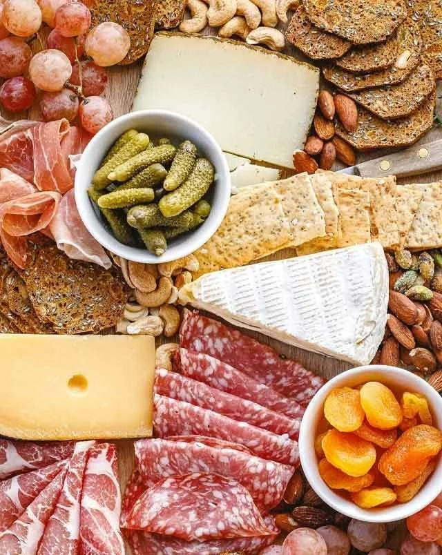 A beautifully arranged cheese board featuring various cheeses and accompaniments.