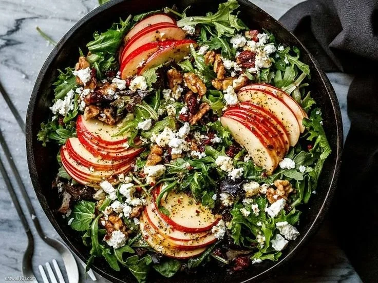 Creamy Cucumber Salad 1 Creamy cucumber salad served in a bowl with fresh herbs and vegetables