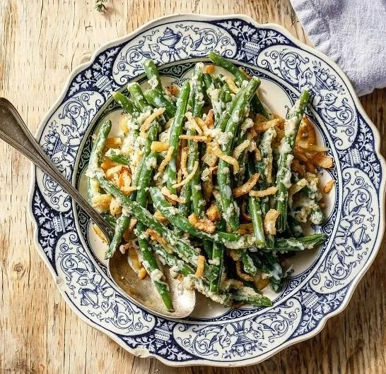 Delicious green bean casserole topped with crispy onions and served in a baking dish