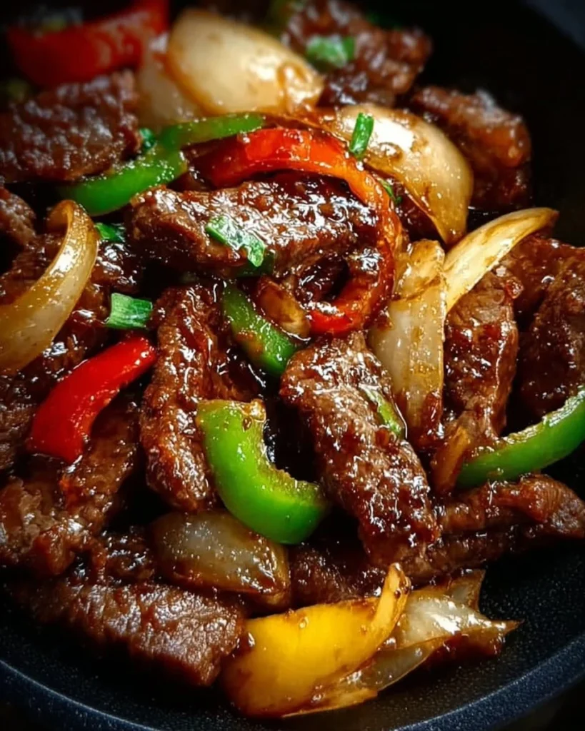 Sizzling Chinese Pepper Steak with Onions served on a plate
