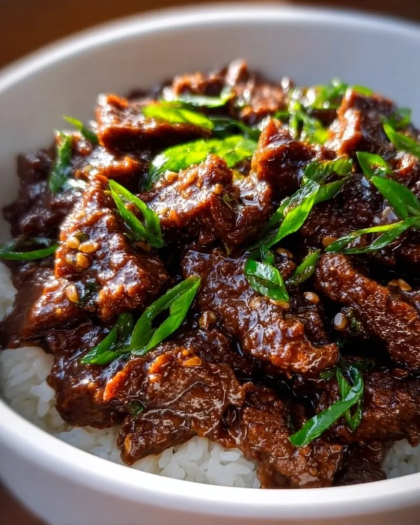 Delicious Slow Cooker Mongolian Beef served over rice with green onions