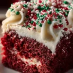 Christmas Red Velvet Poke Cake topped with cream cheese frosting and festive decorations.