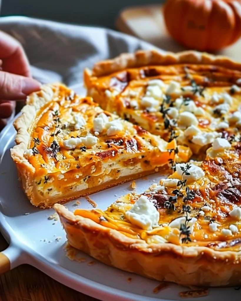 Savory pumpkin quiche with feta cheese and thyme on a rustic table setting
