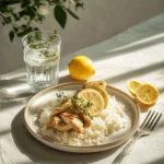 Plate of Lemon Chicken served with rice and garnished with fresh herbs